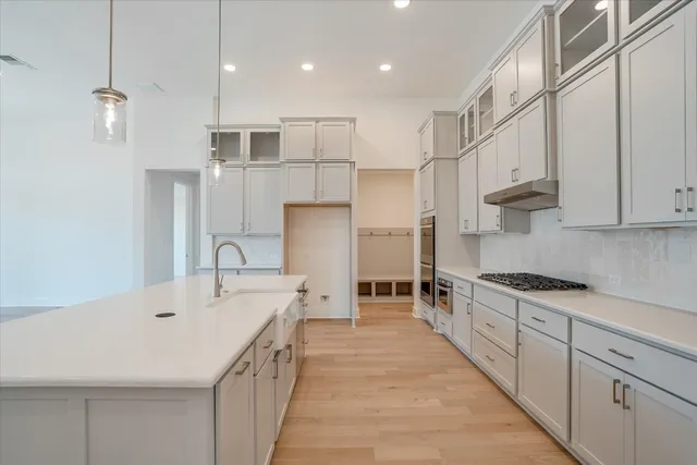 a large kitchen with stainless steel appliances kitchen island granite countertop a sink and cabinets