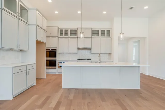 a large kitchen with kitchen island a sink a center island stainless steel appliances and a counter top