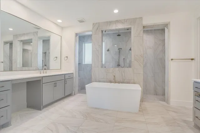 a spacious bathroom with a double vanity sink mirror and a bathtub