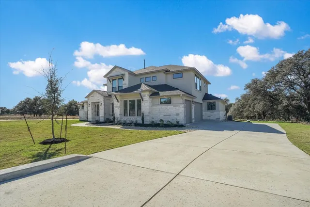 a front view of a house with a yard and entertaining space