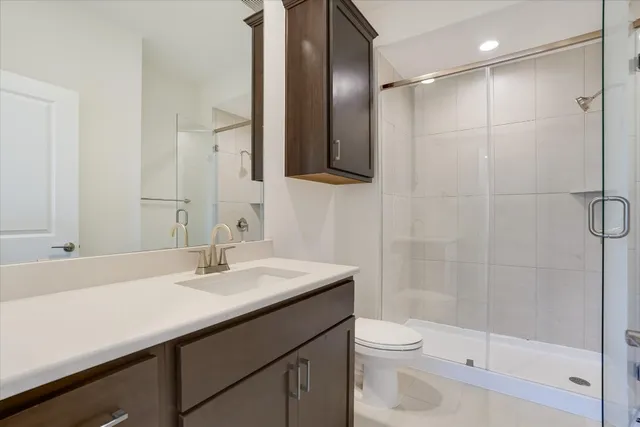 a bathroom with a sink a toilet and shower