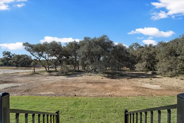 a view of a yard with wooden fence
