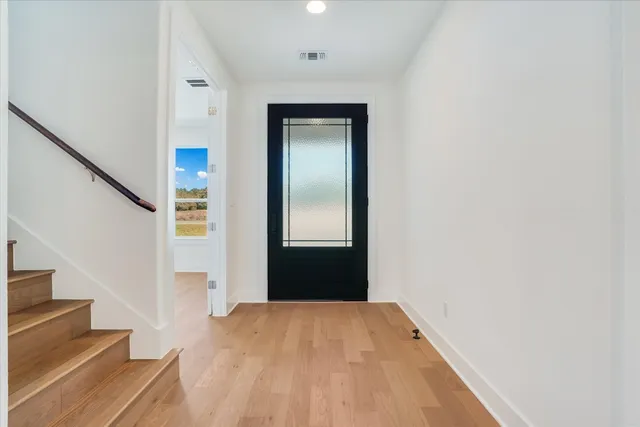 a view of a hallway with wooden floor and staircase