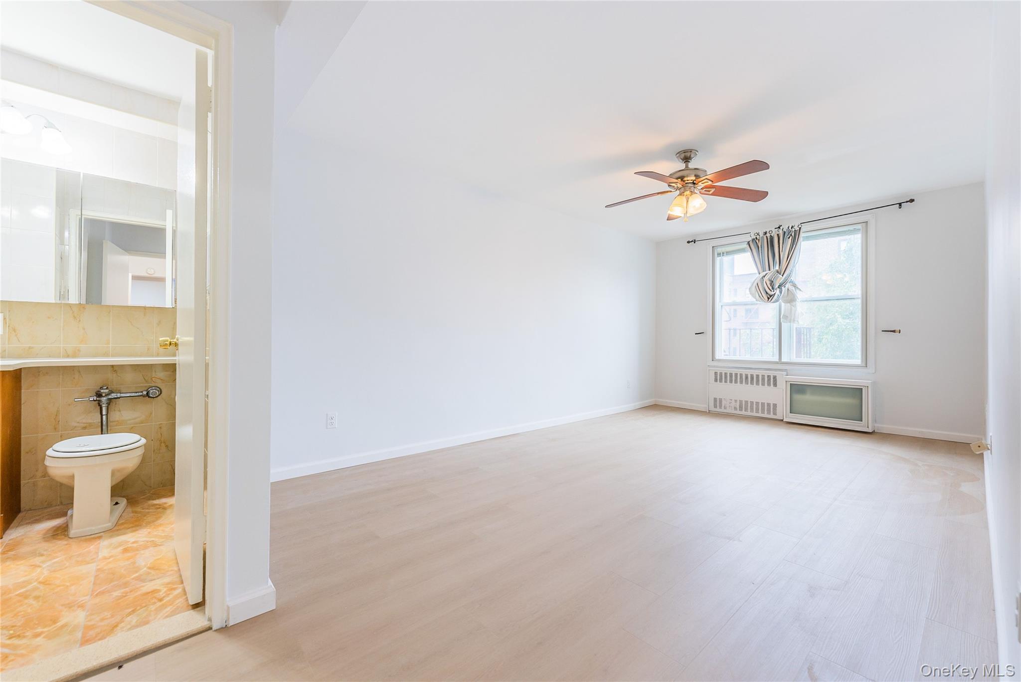 100-26 67th Road, Unit 4F Queens, NY 11375 - Photo 6 of 12 wooden floor in an empty room and a bathroom