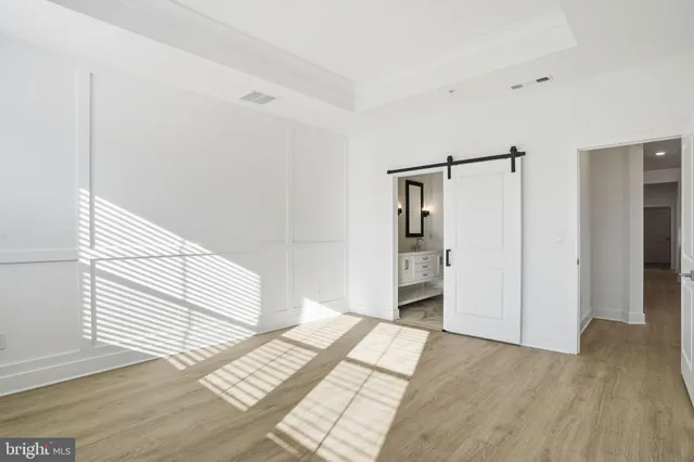 a view of a room with wooden floor and white walls