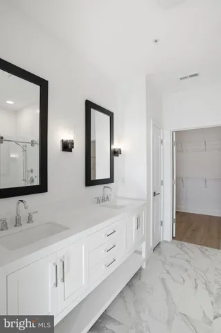 a spacious bathroom with a double vanity sink and a mirror