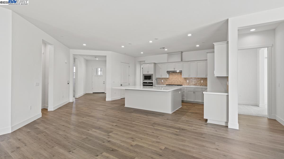 a view of kitchen with kitchen island sink refrigerator and white cabinets