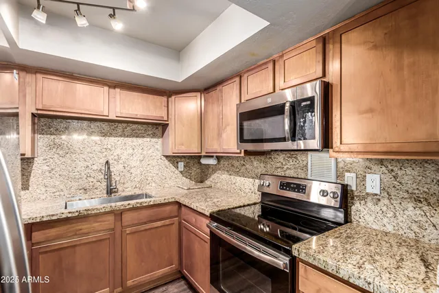 a kitchen with stainless steel appliances granite countertop a stove and a microwave