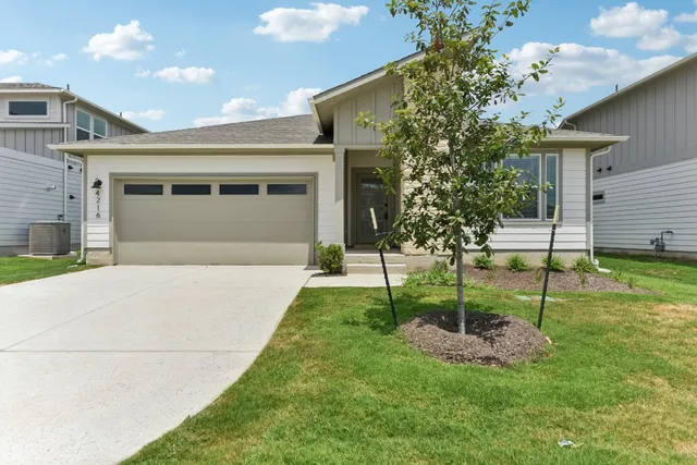 a front view of a house with a yard and a garage
