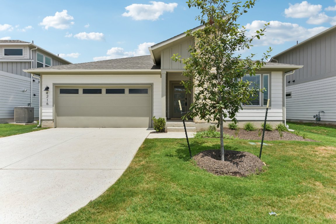 a front view of a house with a yard and a garage