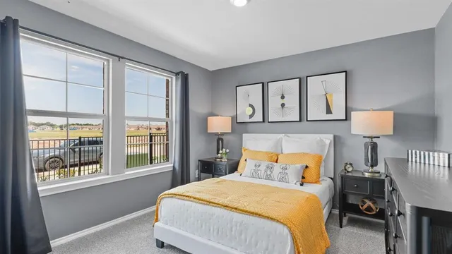 a bedroom with a bed and a lamp on dresser