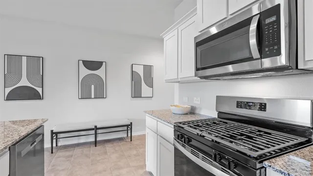 a kitchen with microwave a stove and cabinets