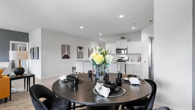 a kitchen with stainless steel appliances kitchen island granite countertop a refrigerator and a stove top oven with white cabinets