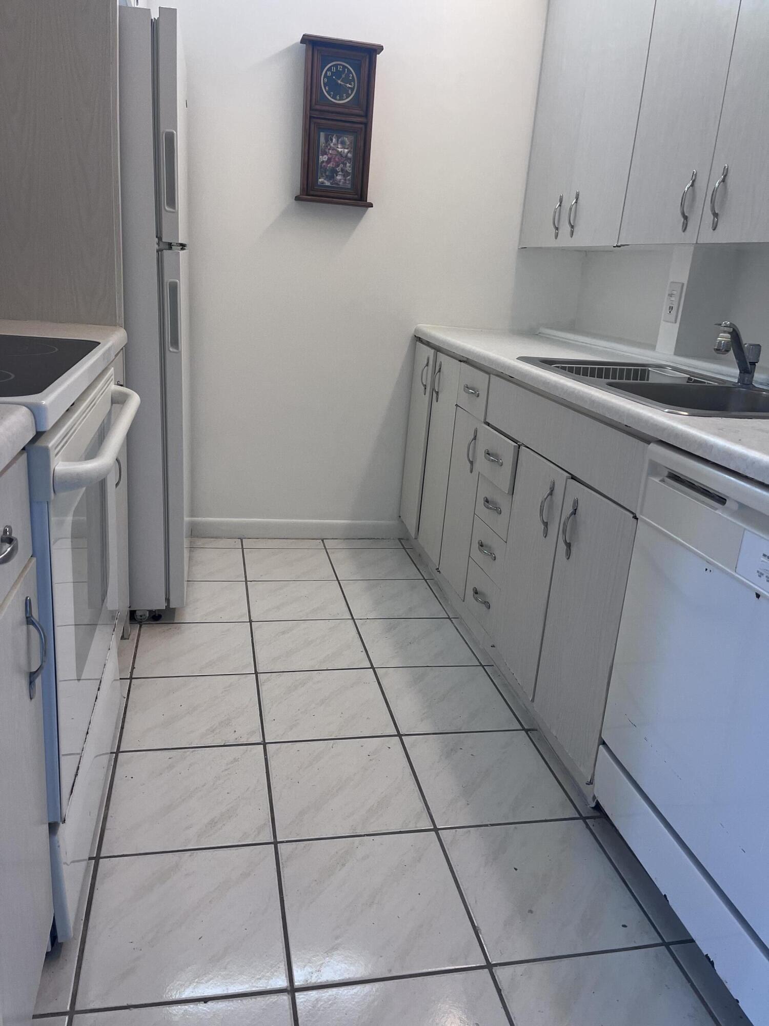 4302 Martinique Circle, Unit E4 Coconut Creek, FL 33066 - Photo 4 of 12 a utility room with cabinets washer and dryer