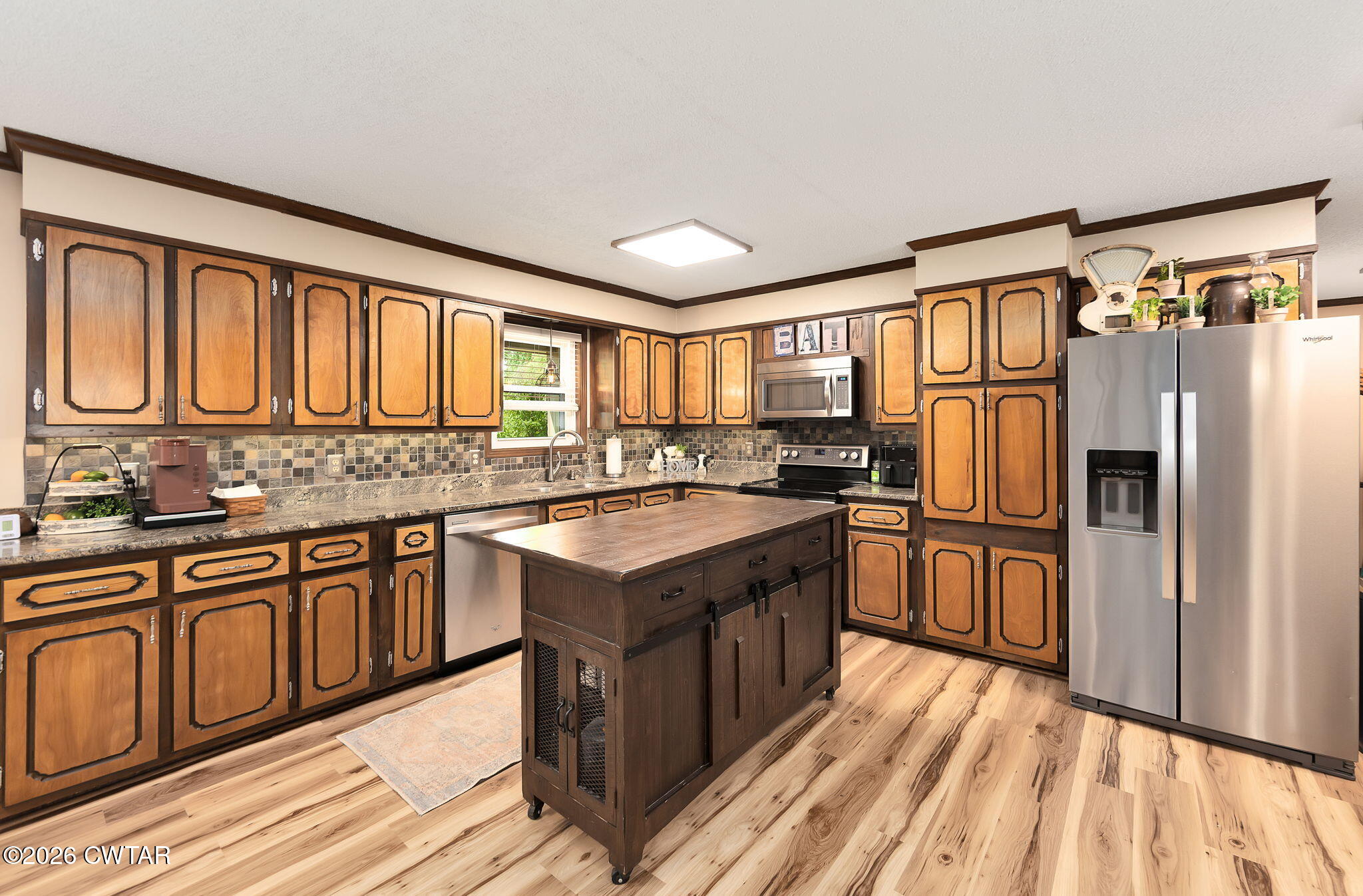 328 New Hope Road Ripley, TN 38063 - Photo 8 of 39 a kitchen with stainless steel appliances granite countertop a refrigerator a sink dishwasher a stove with wooden cabinets and floor