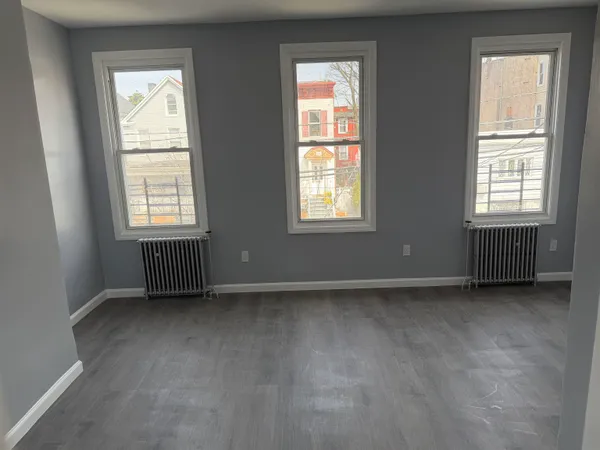 an empty room with wooden floor & closet area