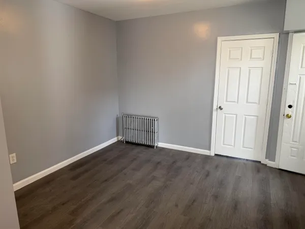 a view of an empty room with wooden floor