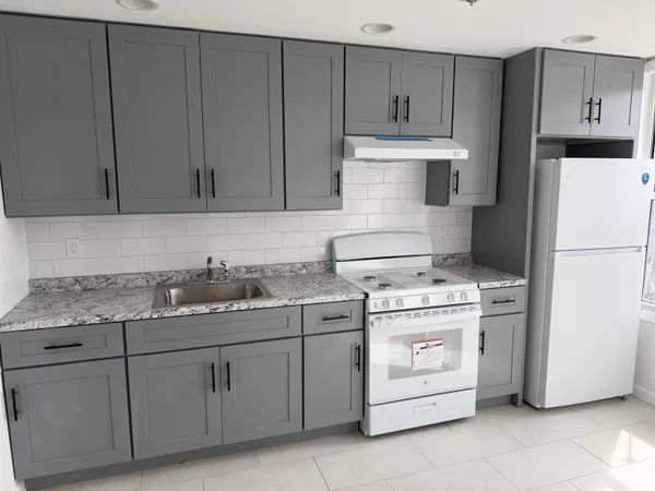 a kitchen with a stove a sink and a refrigerator