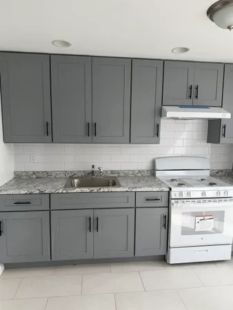 a kitchen with a stove top oven and refrigerator