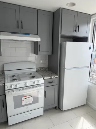a kitchen with stainless steel appliances granite countertop a stove a refrigerator and a cabinets