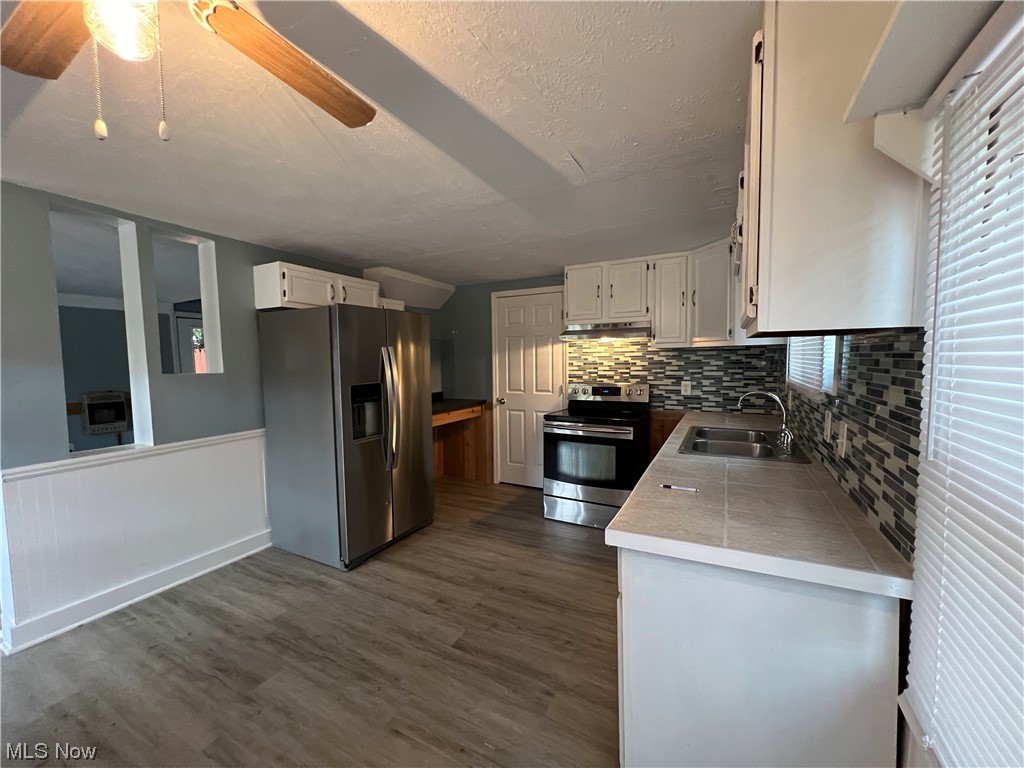 530 South Riverview Road Malta, OH 43758 - Photo 13 of 34 Kitchen with sink, white cabinets, dark hardwood floors, and appliances with stainless steel finishes