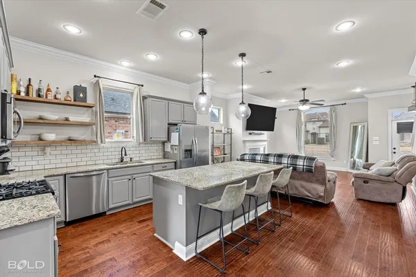a kitchen with stainless steel appliances granite countertop a sink stove and refrigerator
