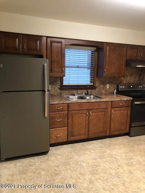 1115 Wheeler Avenue, Unit 1L Dunmore, PA 18510 - Photo 2 of 13 a kitchen with stainless steel appliances granite countertop a refrigerator a sink and a stove