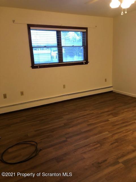 1115 Wheeler Avenue, Unit 1L Dunmore, PA 18510 - Photo 7 of 13 an empty room with wooden floor and windows