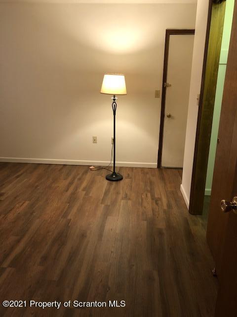 1115 Wheeler Avenue, Unit 1L Dunmore, PA 18510 - Photo 8 of 13 an empty room with wooden floor and mirror