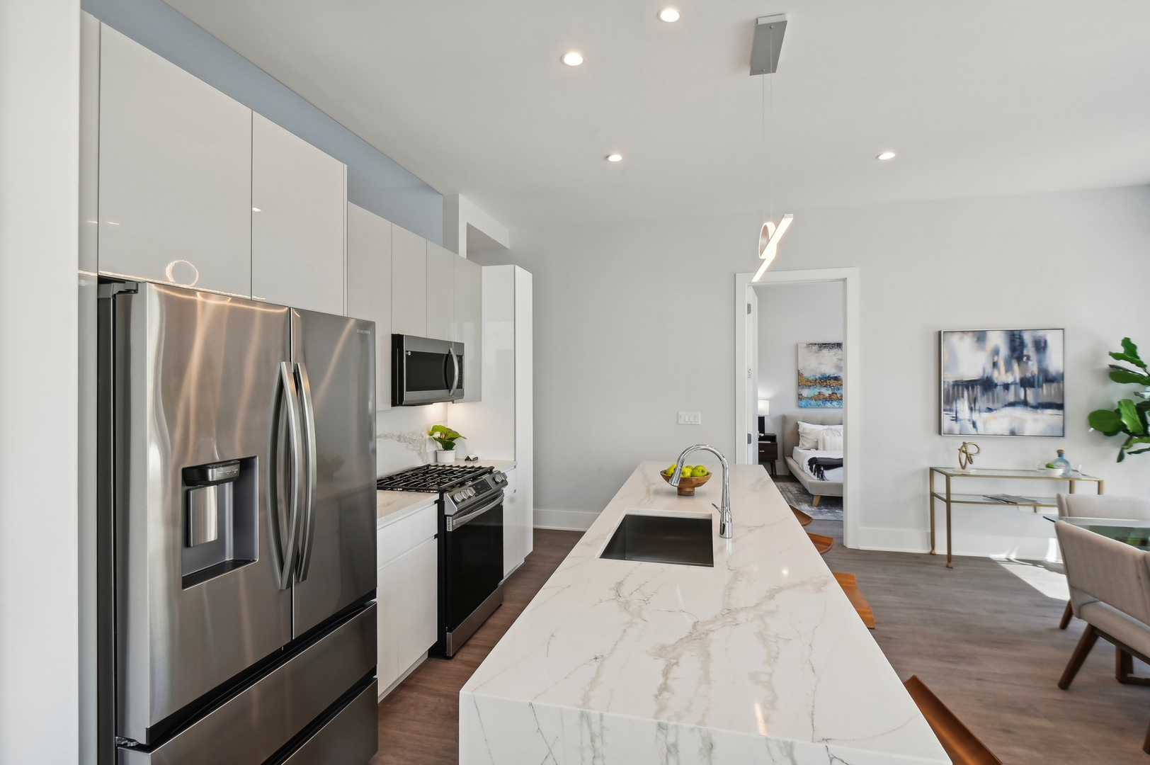 812 West Adams Street, Unit 600 Chicago, IL 60607 - Photo 16 of 46 a kitchen with stainless steel appliances a refrigerator a stove a sink a dining table and chairs with wooden floor