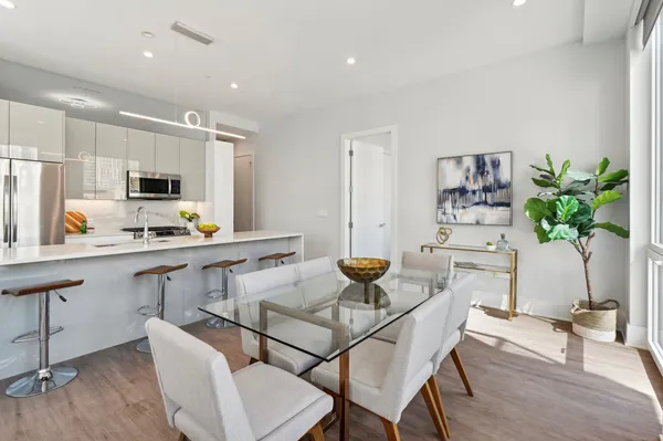a dining room with furniture a rug and a floor to ceiling window