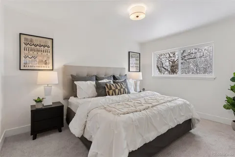 a bedroom with bed and paintings on the wall