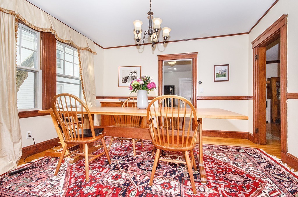 21 Watson Road, Unit 21 Belmont, MA 02478 - Photo 9 of 20 a dining room with wooden floor a chandelier a wooden table and chairs