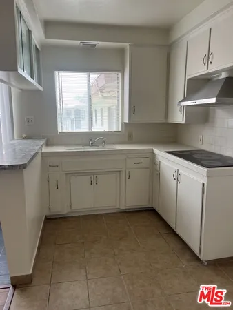 a kitchen with cabinets appliances and a window