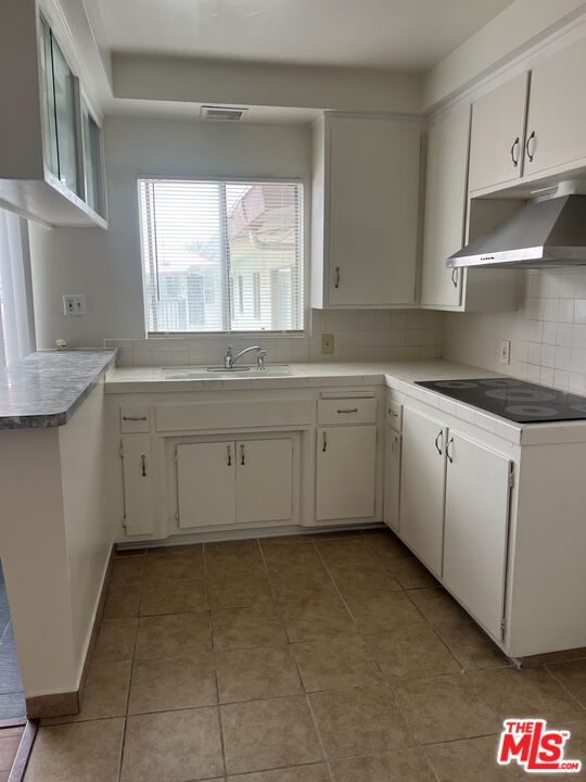 a kitchen with cabinets appliances and a window