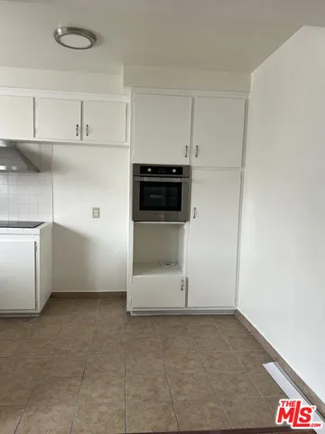 a view of a kitchen with an empty space and cabinets