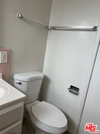 a white toilet sitting next to a shower