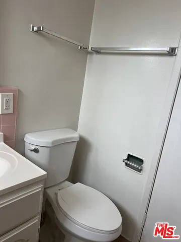 a white toilet sitting next to a shower