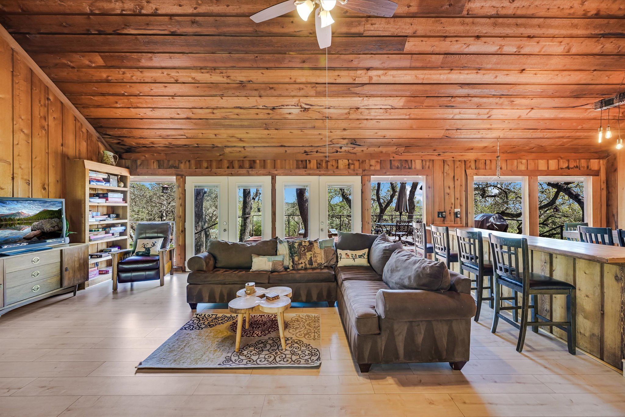 411 Whitetail Ridge Austin, TX 78737 - Photo 4 of 38 Living room with plenty of natural light, wooden walls, a vaulted wood ceiling, ceiling fan, and light wood-type flooring