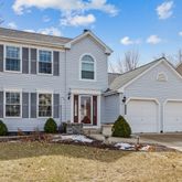 a view of a white house with a yard and potted plants