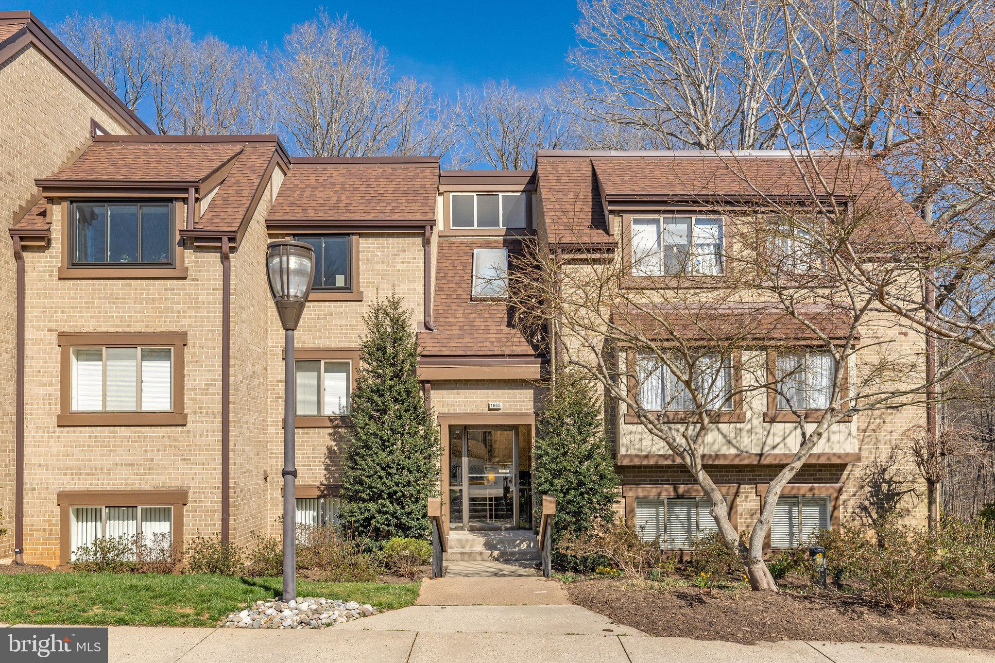 1665 Parkcrest Circle, Unit 301 Reston, VA 20190 - Photo 1 of 36 a front view of a house with garden