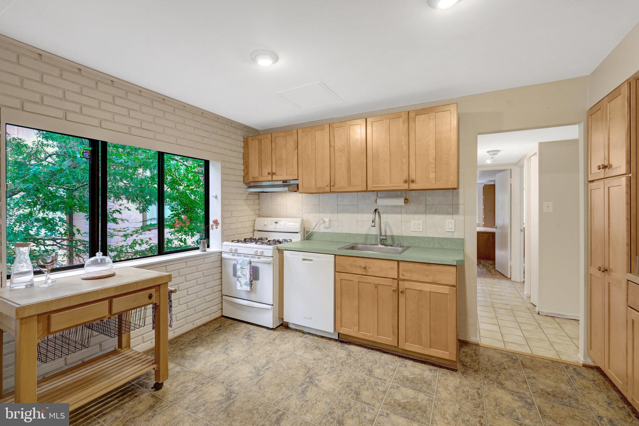 1665 Parkcrest Circle, Unit 301 Reston, VA 20190 - Photo 11 of 36 a kitchen with sink a stove and white cabinets