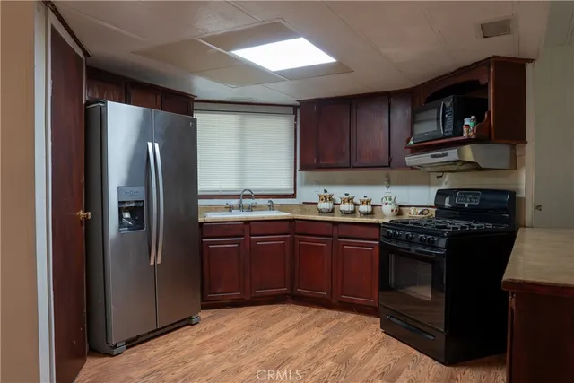 a kitchen with stainless steel appliances granite countertop a stove refrigerator and a microwave