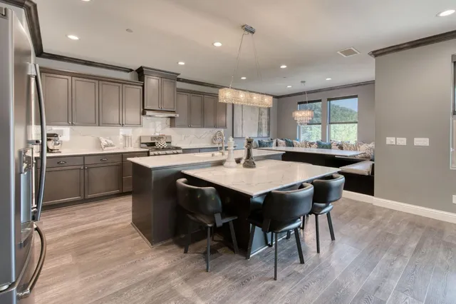 a kitchen with stainless steel appliances granite countertop a sink stove and refrigerator