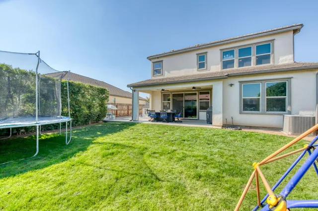 a front view of a house with barbeque oven and furniture
