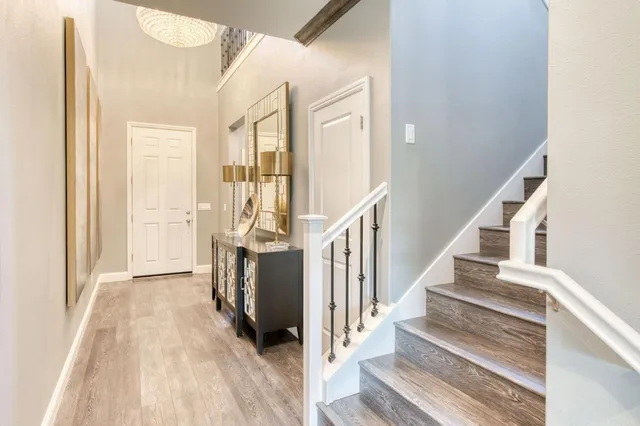 a view of a hallway with wooden floor and staircase