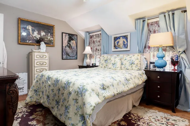 a bedroom with a bed and a lamp on dresser