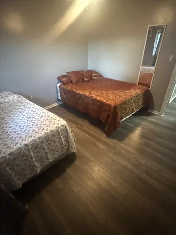 a bedroom with two bed and a mirror