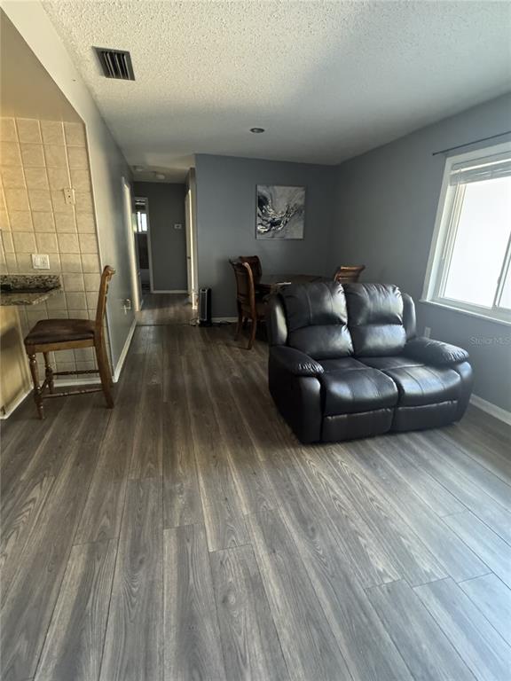 1702 Hickorywood Lane Orlando, FL 32818 - Photo 6 of 8 a living room with furniture and a wooden floor
