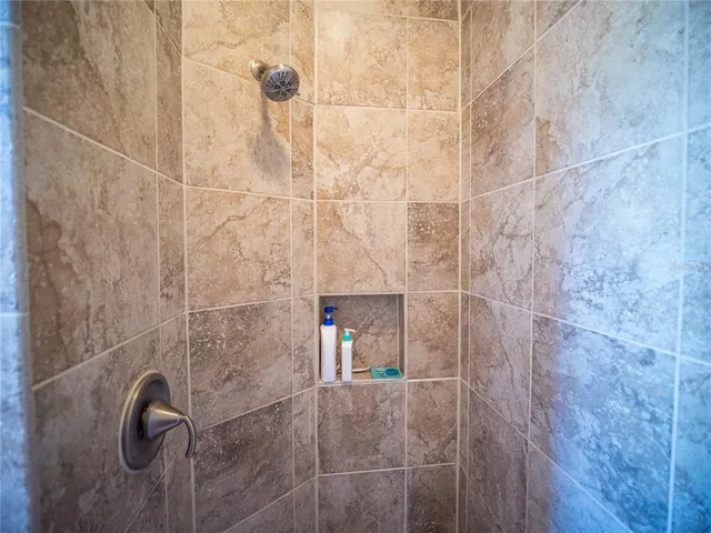 a bed sitting in a bedroom next to a window with a bookshelf and a wooden floor